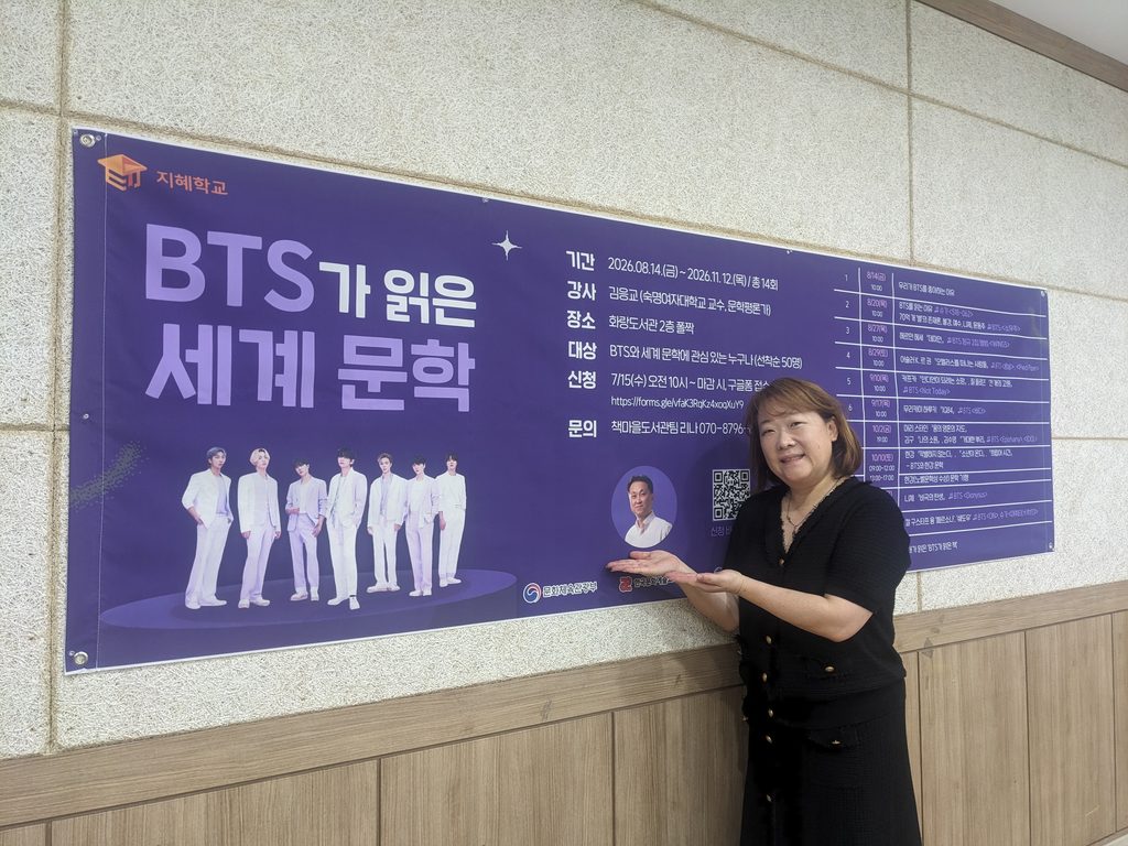화랑도서관에서 진행 중인 ‘BTS가 읽은 세계문학’ 강좌 안내 현수막 앞에서 한 수강생이 포즈를 취하고 있다.